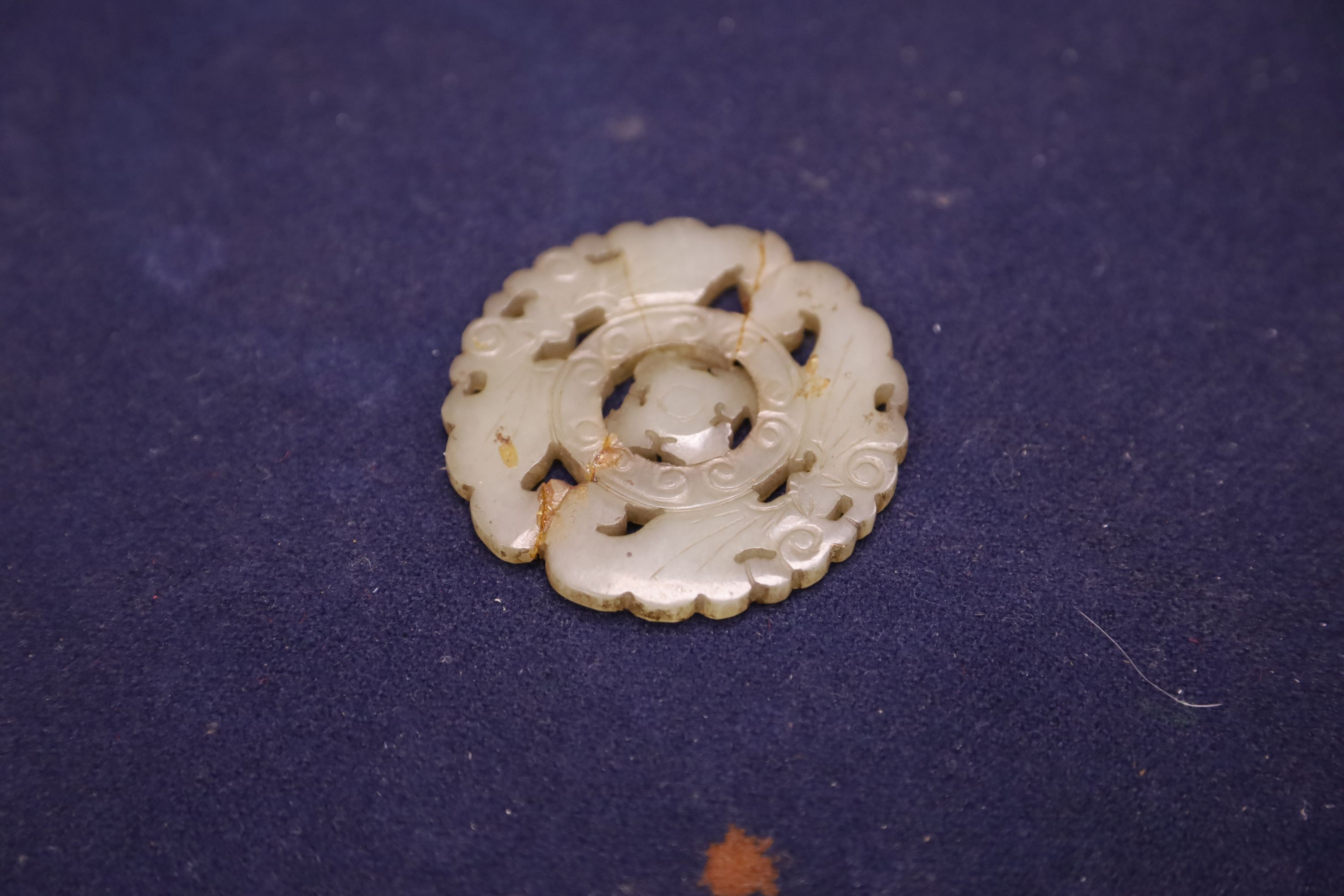 A Chinese small celadon jadeite lion on stand, a small jade circular plaque on stand (damage) and sundry items